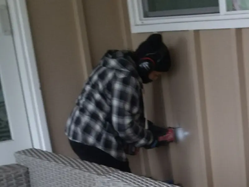Professional electrician installing an exterior outlet in Millis